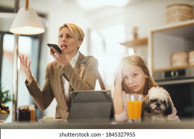 Shot Of A Frustrated Teenage Girl Sitting With Her Cute Dog Waiting For Her Stressed Mom To Finish Talking On Smart Phone At Her Home While Getting Ready To Go To Work.