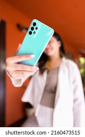 Shot Of Girl's Hand Holding Mobile Phone Taking Selfie. Asian Girl Using Smart Phone Outdoor.Shallow Depth Of Field With Focus On Hand Holding Cellphone.