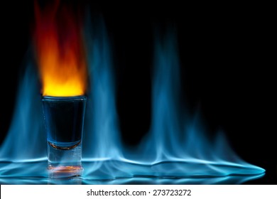 shot glass on fire against black background