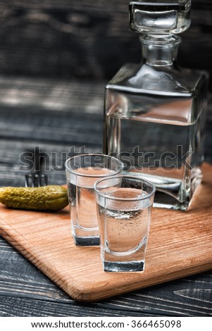 Shot glasses with vodka and pickled cucumbers on a fork