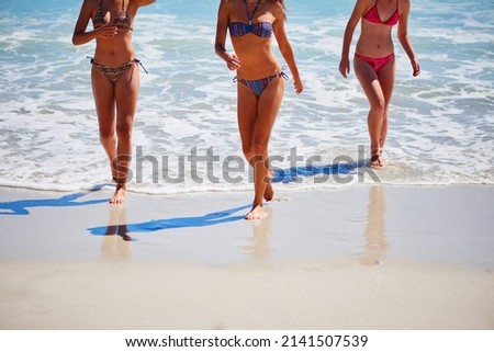 Shot of a group of best friends spending the day at the beach swimming