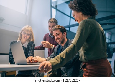 Shot Of A Group Of Coworkers Looking At A Laptop Computer