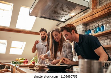 Shot of a group of friends cooking in the kitchen together - Powered by Shutterstock