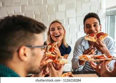 Shot Of A Group Of Friends Eating Pizza In A Bar