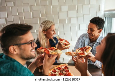 Shot Of A Group Of Friends Eating Pizza In A Bar