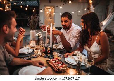 Shot Of A Group Of Friends Having Dinner Outside