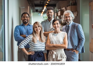 Shot of a group of well-dressed businesspeople standing together. Successful business team smiling teamwork corporate office colleague. Ready to make success happen - Shutterstock ID 2045941859