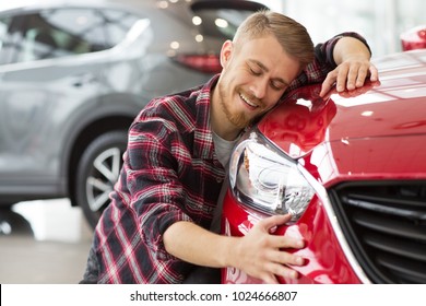 Shot of a handsome young happy bearded man embracing his new car at the dealership smiling joyfully with his eyes closed copyspace happiness love travelling vehicle automotive transport.