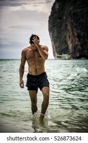  Shot Of A Handsome Young Man Standing On A Beach In Phuket Island, Thailand, Shirtless Wearing Boxer Shorts, Showing Muscular Fit Body