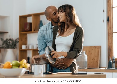 Shot of happy beautiful couple cooking together in the kitchen at home - Powered by Shutterstock