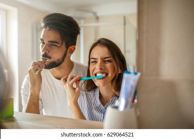 Shot of a happy couple bonding while brushing teeth in the bathroom.
