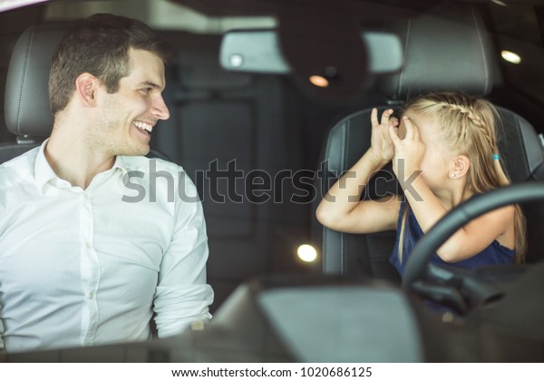 Shot of a\
happy father and daughter having fun making funny faces sitting in\
a car together family playtime bonding kids children parenting\
parenthood recreation travel\
emotions