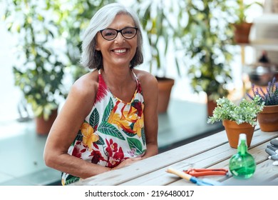 Shot of happy senior woman taking care of her plants while looking at camera in her greenhouse - Powered by Shutterstock