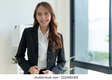 Shot Of Happy Young Asian Woman Looking At Camera, Attractive Businesswoman Standing In Her Workstation Office.