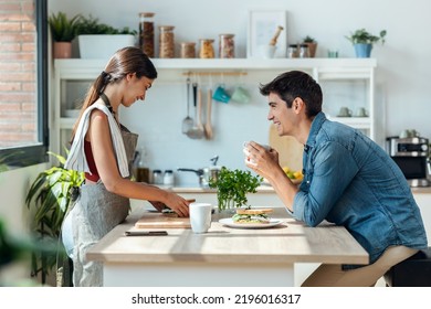 Shot of happy young couple enjoying breakfast while talking in the kitchen at home. - Powered by Shutterstock