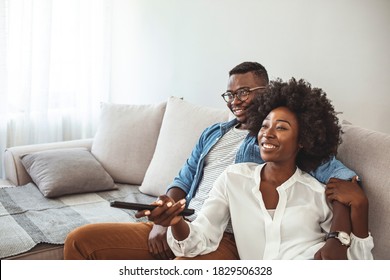 Shot of a happy young couple watching tv together at home. It’s not a cinema but it’s every bit as good. Shot of a couple resting on the couch watching television
