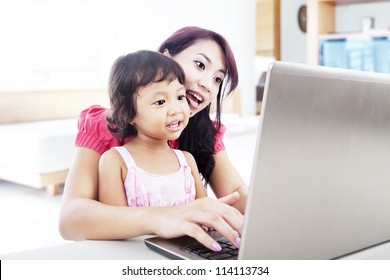 Shot Of Happy Young Mother And Child With Laptop Computer. Shot At Home