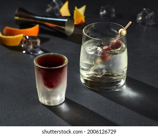 Shot Of Herbal Liqueur And Goblet Of Gin With Ice And Olives