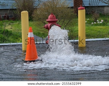 A shot of a hydrant being flushed as water runs out of it.