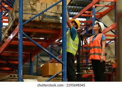 Shot Of Industrial Workers Checking Inventory And Quantity Of Storage Product On Shelf In A Large Warehouse