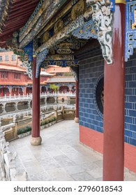 A shot from inside a pavilion showing the structural beauty of red support pillars and highly decorated ceiling beams. The image highlights oriental craftsmanship, cultural richness, and sacred spaces.