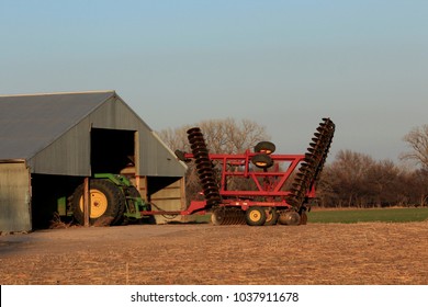 A Shot Of A John Deere Tractor In A Barn With A Disc On The Back Of The Tractor That's Bright And Colorful. On 3-3-2018 Sterling Kansas USA 