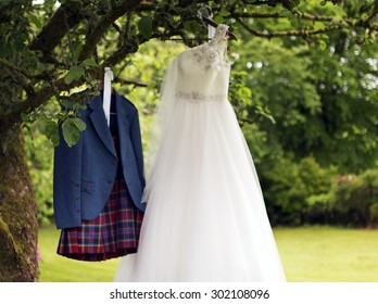 Shot Of A Kilt And Wedding Dress Hanging On A Tree