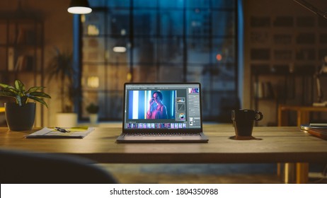 Shot of a Laptop Computer in the Modern Office Showing Photo Editing Software. In the Background Warm Evening Lighting and Open Space Studio with City Window View - Powered by Shutterstock