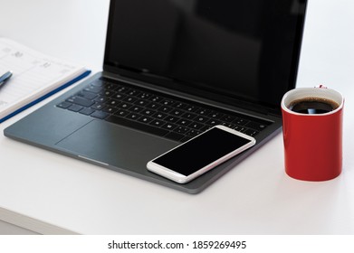 Shot Of A Laptop And Other Various Items On A Work Desk In A Modern Office