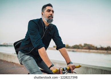 Shot of a man riding his bicycle by the river - Powered by Shutterstock