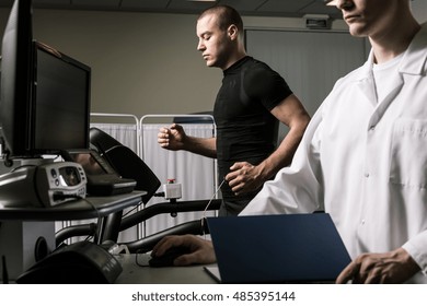 Shot of a man running on a treadmill with electrode attachted to his body and a young doctor - Powered by Shutterstock