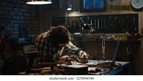 Shot of a man soldering drone in a garage
