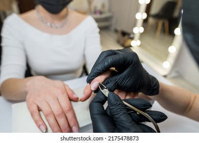 Shot Of A Manicurist Using A Cuticle Clipper To Give A Nail Manicure To Her Client In The Beauty Salon. Master Of Manicure Remove A Cuticle Nail With Nail Clipper.