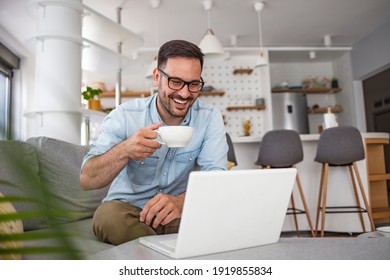 Shot Of A Mature Man Sitting On A Chair In His Living Room Using A Laptop. Man With Good Vibes Sitting On The Sofa. Man Studying And Working On Laptop At Home