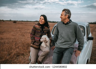 Shot Of A Middle Aged Couple Enjoying A Day In Nature With Their Dog