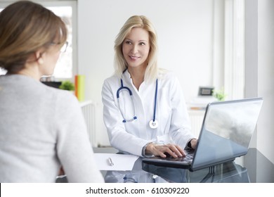 Shot Of A Middle Aged Female Doctor Sitting In Front Of Laptop And Consulting With Her Patient.