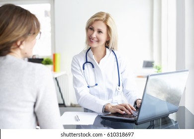 Shot of a middle aged female doctor sitting in front of laptop and consulting with her patient.