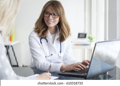 Shot Of A Middle Aged Female Doctor Sitting In Front Of Laptop And Consulting With Her Patient.