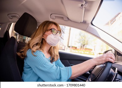 Shot Of Middle Aged Woman Wearing Face Mask While Driving Her Car During Coronavirus Pandemic. 
