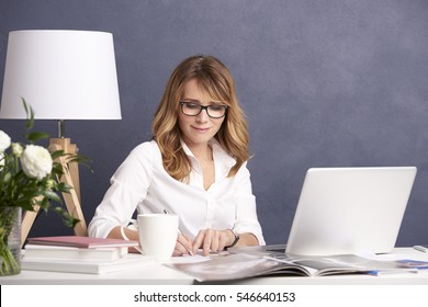 Shot Of A Middle Aged Woman Working From Home While Sitting At Desk In Front Of Laptop.