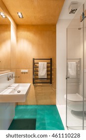 Shot of a minimalistic bathroom interior with cyan floor and orange walls