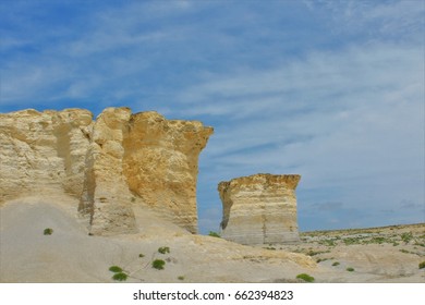 A shot of Monument Rock in Western Kansas thats just south of Oakley Kansas from Interstate 70 Highway. With green weeds, blue sky, and white clouds.