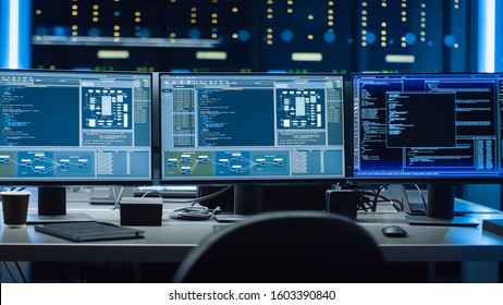 Shot of Multiple Personal Computer Monitors Showing Coding Language Program with System Monitoring Interface. In the Background Data Center with Server Racks. - Shutterstock ID 1603390840