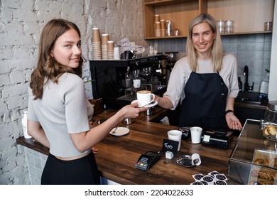 Shot Of Old Woman Coffee Maker Serving Her Customer In Coffee Bar.