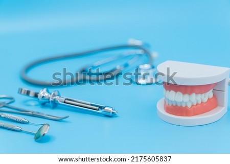 Shot of Oral dental care equipment putting in blue background. Tooth structure model and toothbrush put on table, Oral care health concept.