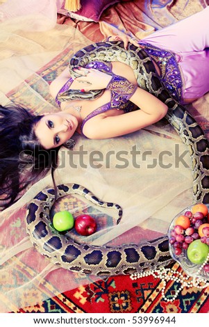 Shot of an oriental woman posing with a python.