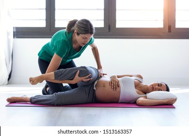 Shot of physiotherapist helping to beautiful pregnant woman for doing pilates exercises preparing for childbirth. - Powered by Shutterstock