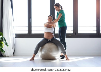 Shot of physiotherapist helping to beautiful pregnant woman for doing pilates exercises with ball preparing for childbirth. - Powered by Shutterstock