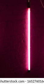 A shot of a pink neon tube handing from an exposed brick wall  - Shutterstock ID 1652760166