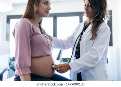 Shot of pretty young woman gynecologist checking the heartbeat baby of her pregnant patient in the clinic. - Powered by Shutterstock